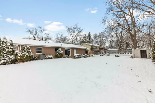 a front view of a house with a yard covered in snow