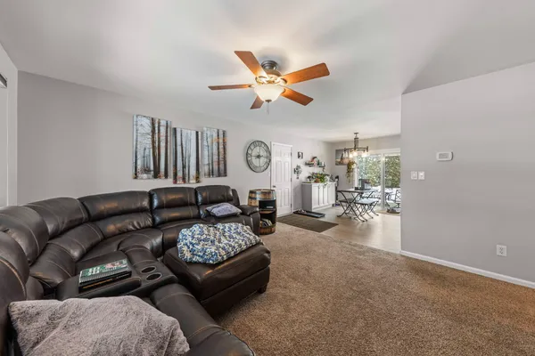 a living room with furniture a clock and a ceiling fan