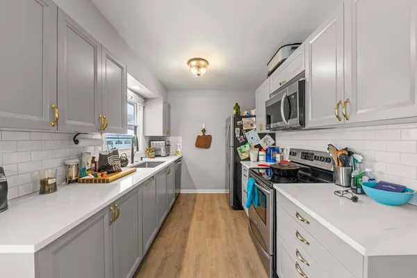 a kitchen with stainless steel appliances a sink stove top oven and cabinets