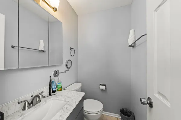 a bathroom with a granite countertop sink mirror vanity and toilet