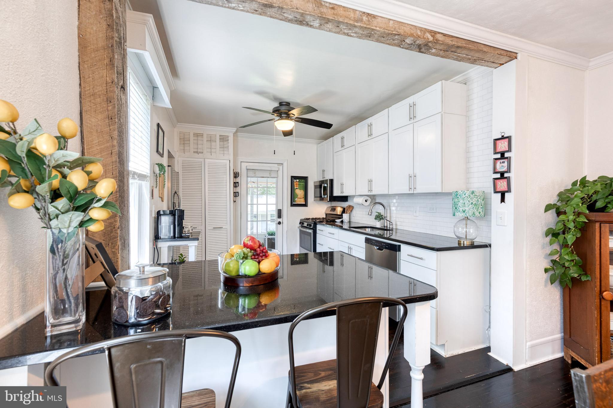 6504 Maplewood Road Baltimore, MD 21212 - Photo 15 of 45 a view of kitchen island with stainless steel appliances sink refrigerator dining table and chairs