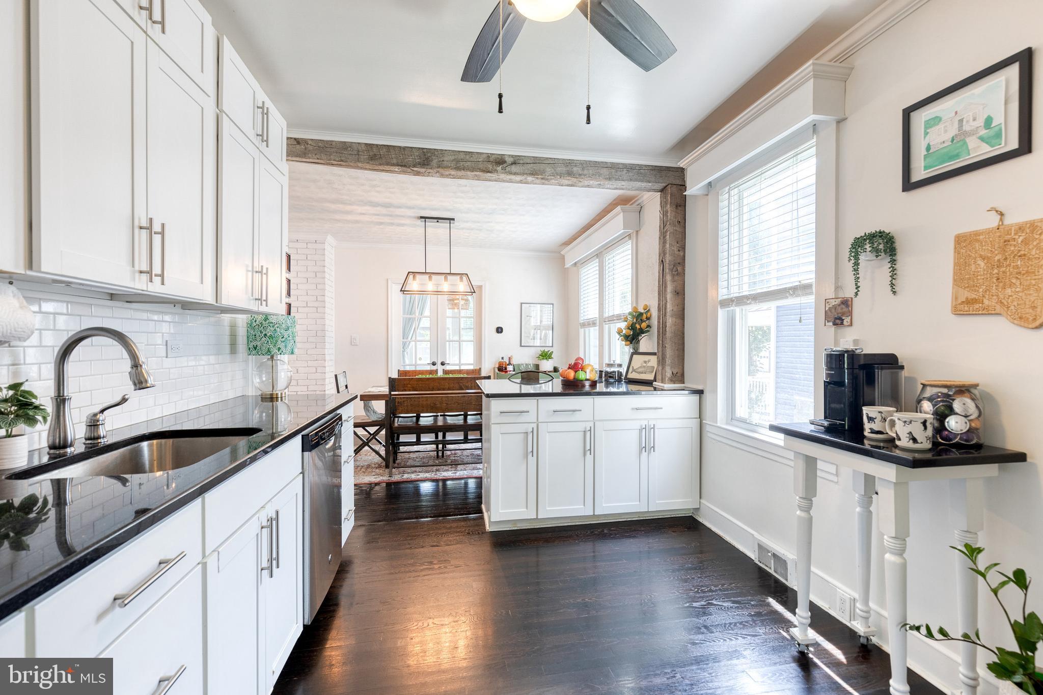 6504 Maplewood Road Baltimore, MD 21212 - Photo 9 of 45 a kitchen with stainless steel appliances a sink dishwasher a stove and white cabinets with wooden floor