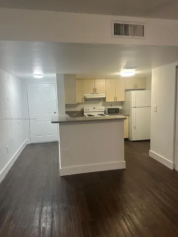 a kitchen with stainless steel appliances a sink and wooden floor