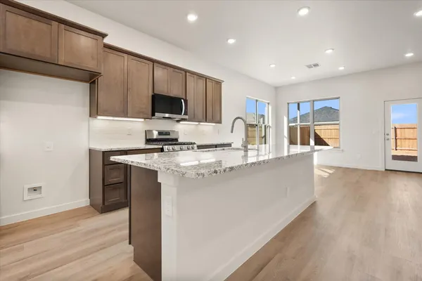 a kitchen with stainless steel appliances granite countertop a sink and a stove top oven