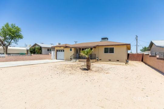 240 West Graaf Avenue Ridgecrest, CA 93555 - Photo 2 of 28 a front view of a house with a dirt yard with a stove