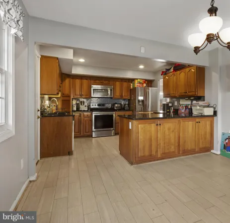a kitchen with stainless steel appliances kitchen island granite countertop a stove and a refrigerator