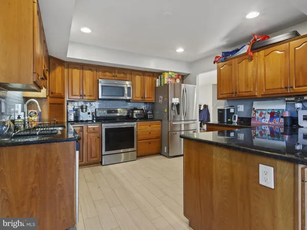 a kitchen with stainless steel appliances granite countertop a stove a sink dishwasher and a microwave oven with cabinets