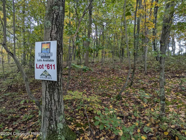 a sign that is sitting in front of a tree