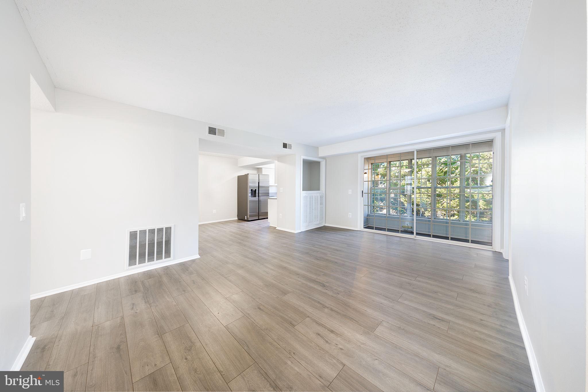 118 Fort Evans Road Southeast, Unit C Leesburg, VA 20175 - Photo 12 of 35 a view of an empty room with wooden floor and a window