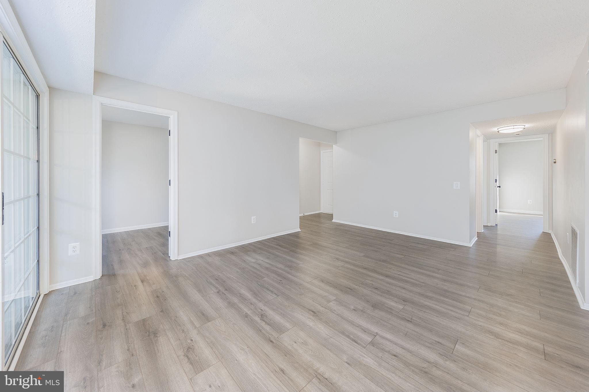 118 Fort Evans Road Southeast, Unit C Leesburg, VA 20175 - Photo 13 of 35 an empty room with wooden floor and windows