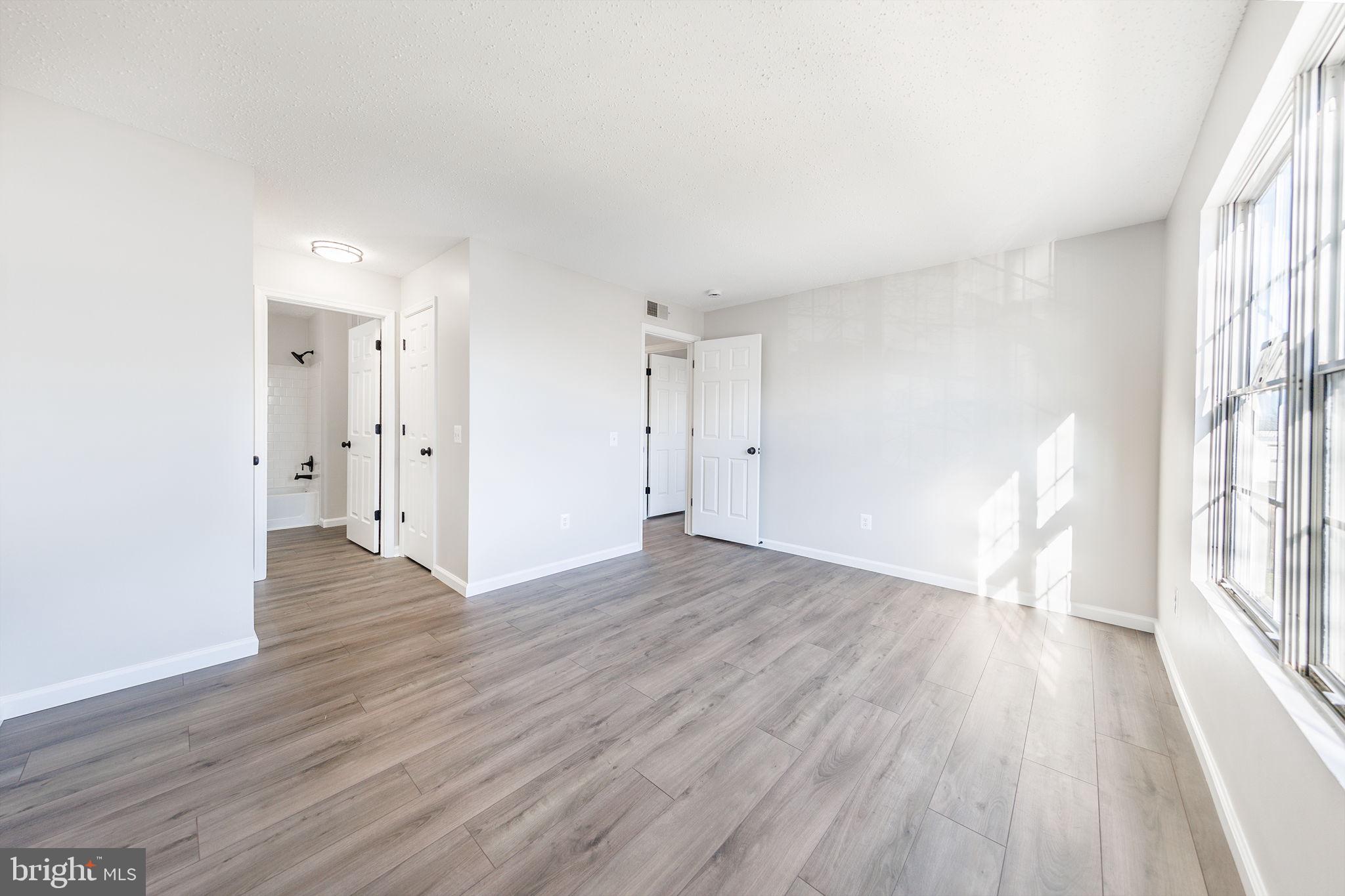 118 Fort Evans Road Southeast, Unit C Leesburg, VA 20175 - Photo 17 of 35 a view of an empty room with wooden floor and a window