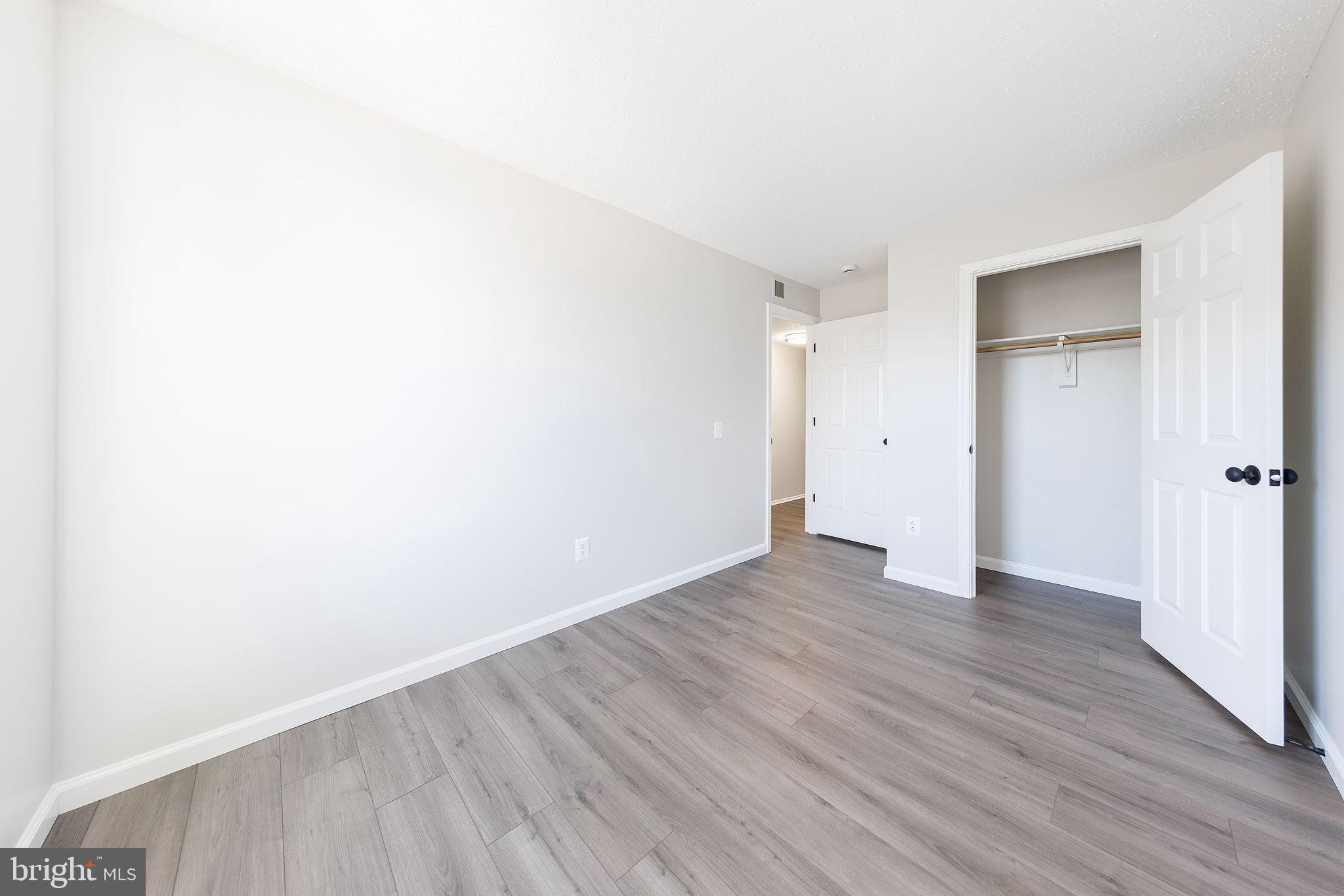 118 Fort Evans Road Southeast, Unit C Leesburg, VA 20175 - Photo 22 of 35 a view of an empty room with wooden floor and closet