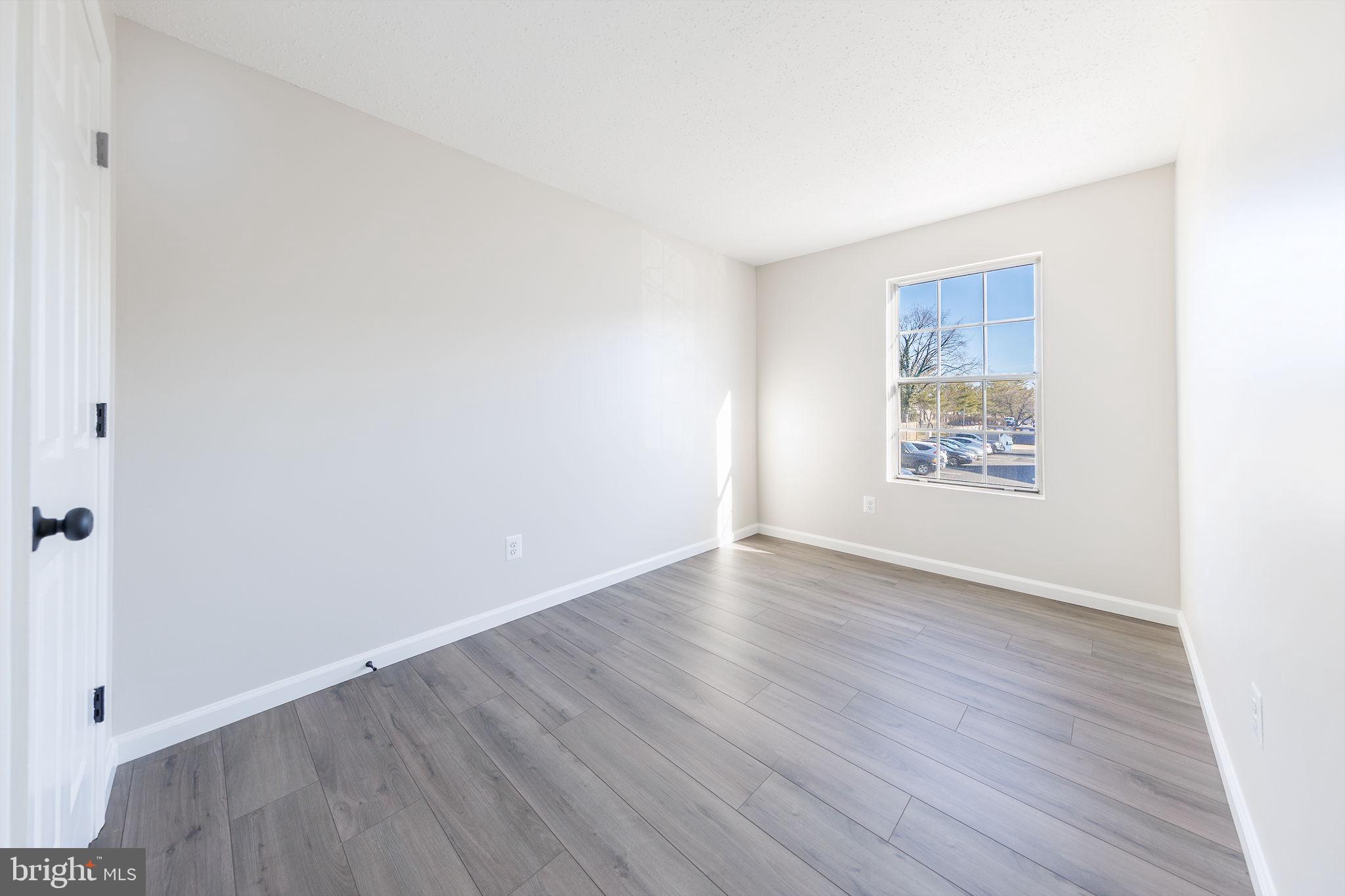 118 Fort Evans Road Southeast, Unit C Leesburg, VA 20175 - Photo 23 of 35 an empty room with wooden floor and windows