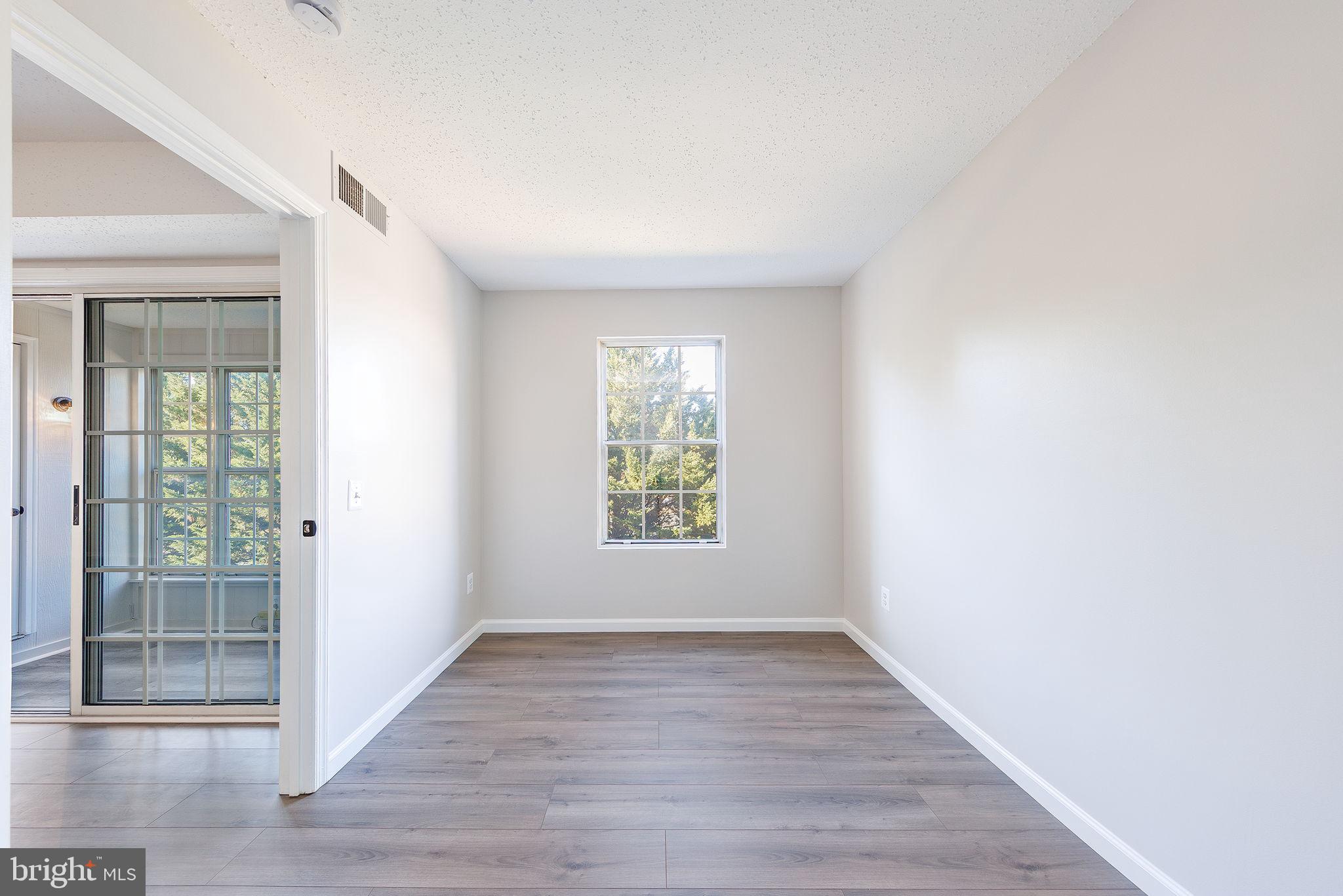 118 Fort Evans Road Southeast, Unit C Leesburg, VA 20175 - Photo 27 of 35 an empty room with wooden floor and windows