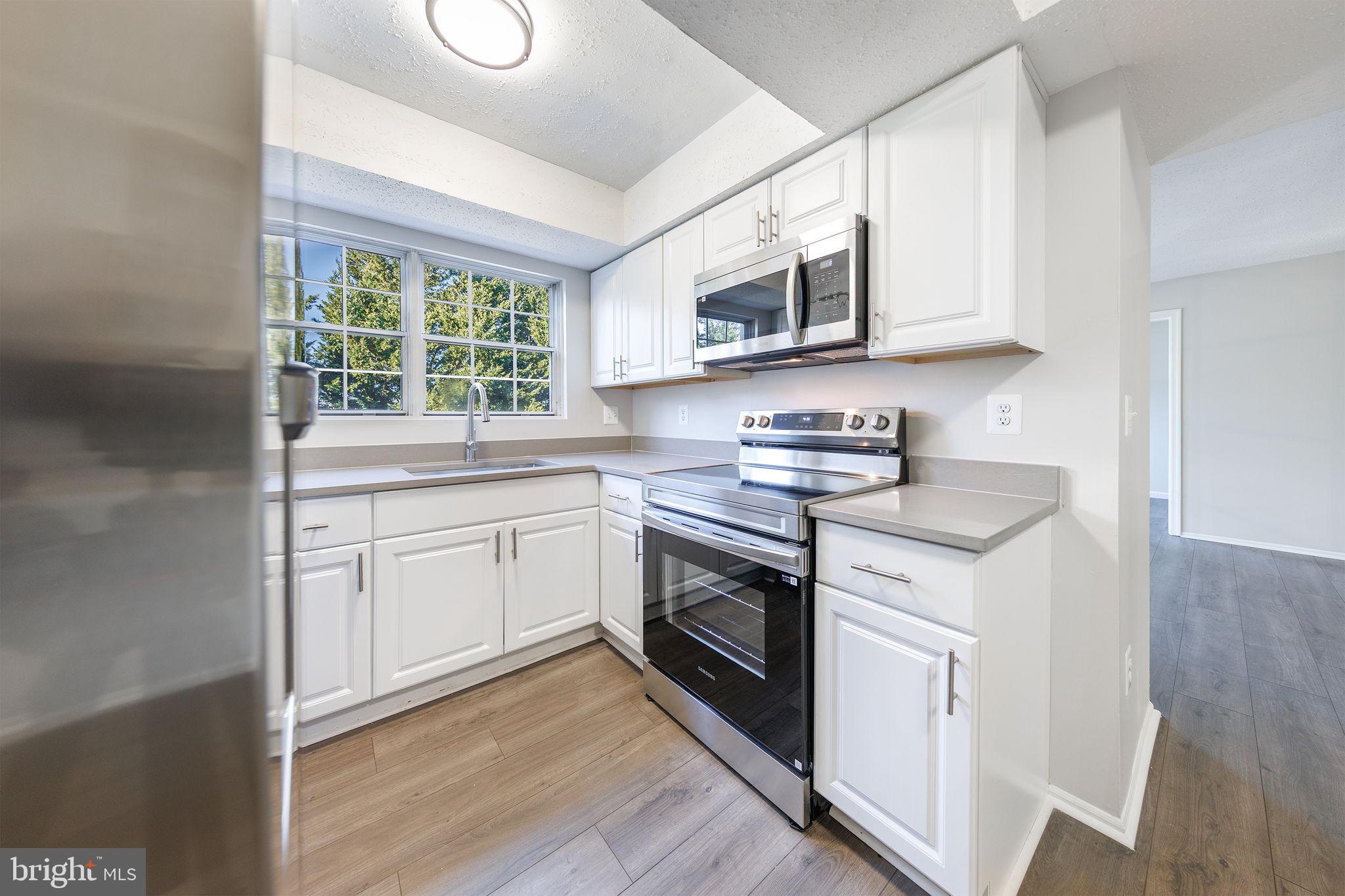 118 Fort Evans Road Southeast, Unit C Leesburg, VA 20175 - Photo 5 of 35 a kitchen with stainless steel appliances granite countertop a sink a stove and a microwave
