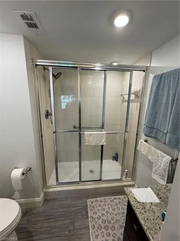 a bathroom with a granite countertop sink toilet and shower