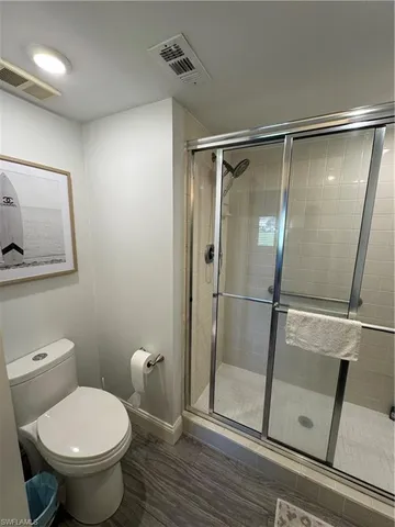 a bathroom with a toilet and a shower