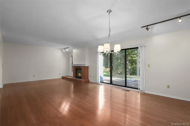 a view of empty room with wooden floor and fireplace