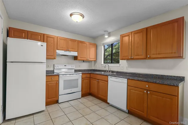 a kitchen with a refrigerator sink and cabinets