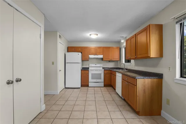 a view of an empty room with window and cabinet