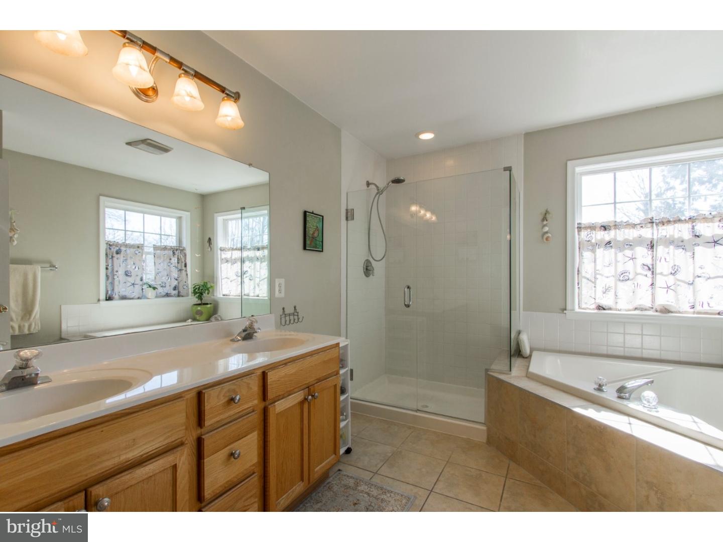 1728 Ridgeway Road Havertown, PA 19083 - Photo 18 of 25 a bathroom with a tub a sink a mirror a shower and a bathtub