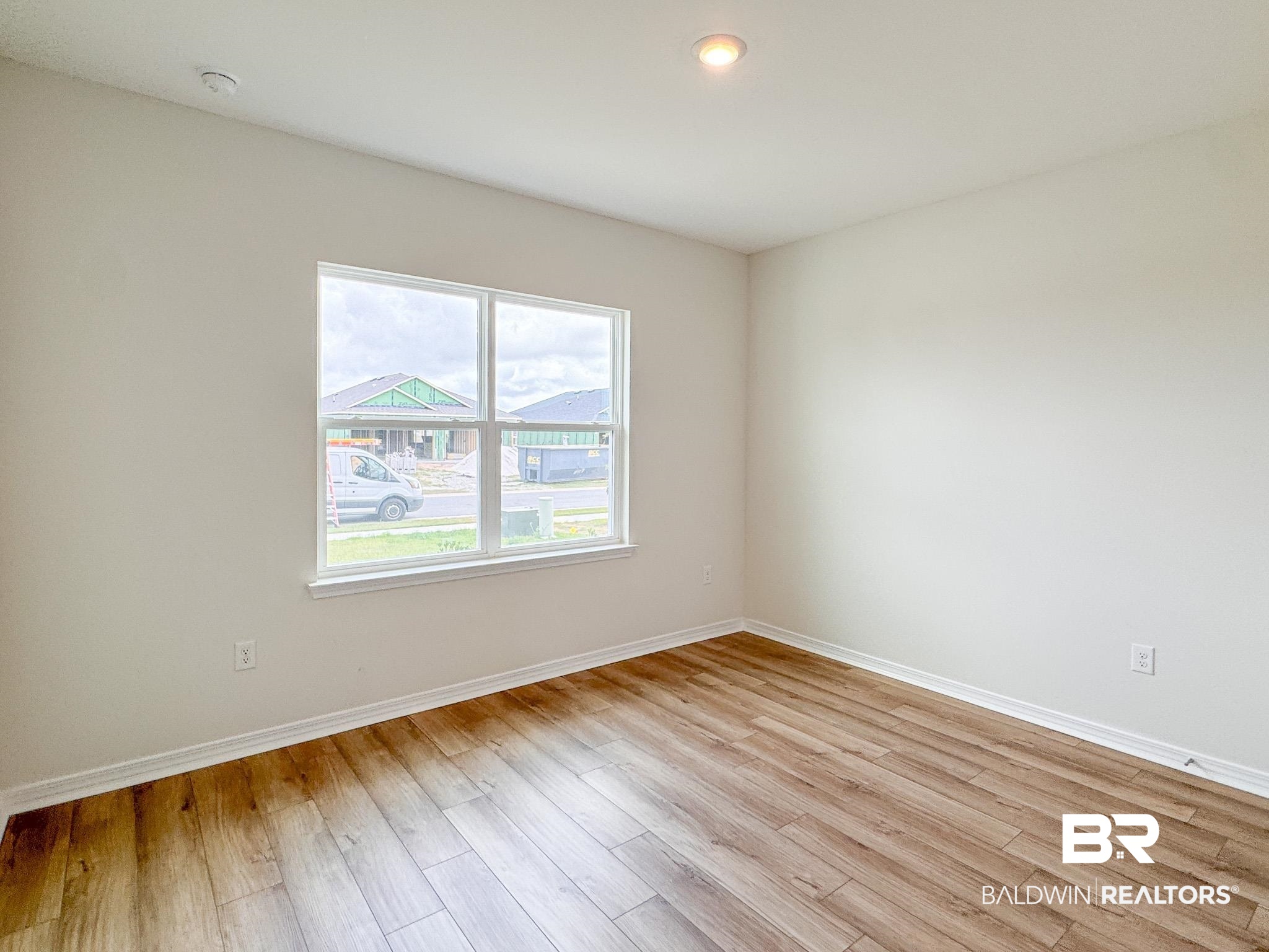 18151 Kent Circle Foley, AL 36535 - Photo 16 of 25 Bright interior space featuring wood-finish flooring, white baseboards, and a large window with white trim