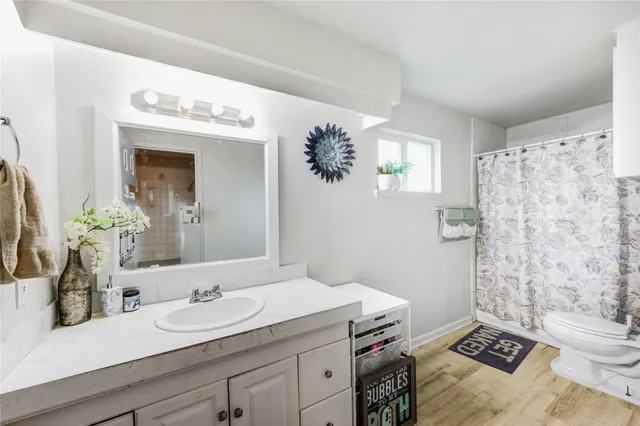a en suite bathroom with a granite countertop sink and a mirror