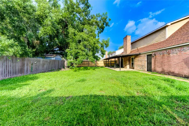 a view of a house with backyard and sitting area
