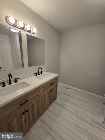 a spacious bathroom with a double vanity sink and a mirror