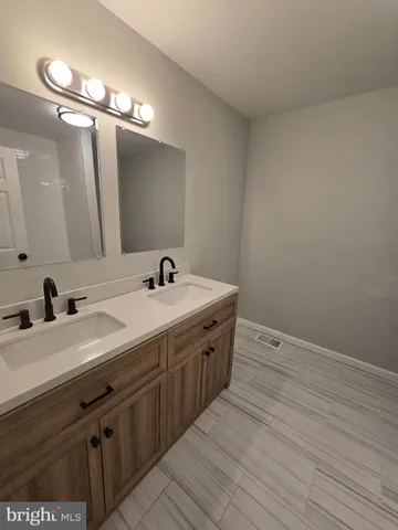 a spacious bathroom with a double vanity sink and mirror