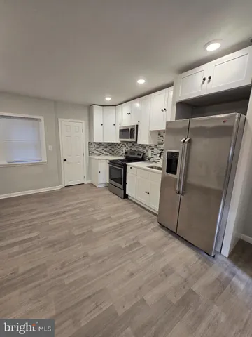 a large kitchen with stainless steel appliances granite countertop a stove a sink and a refrigerator