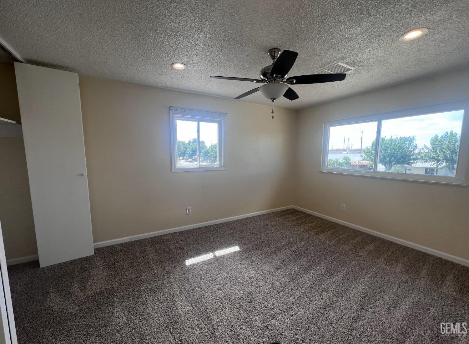 Undisclosed Address Buttonwillow, CA 93206 - Photo 16 of 24 en empty room with windows and ceiling fan