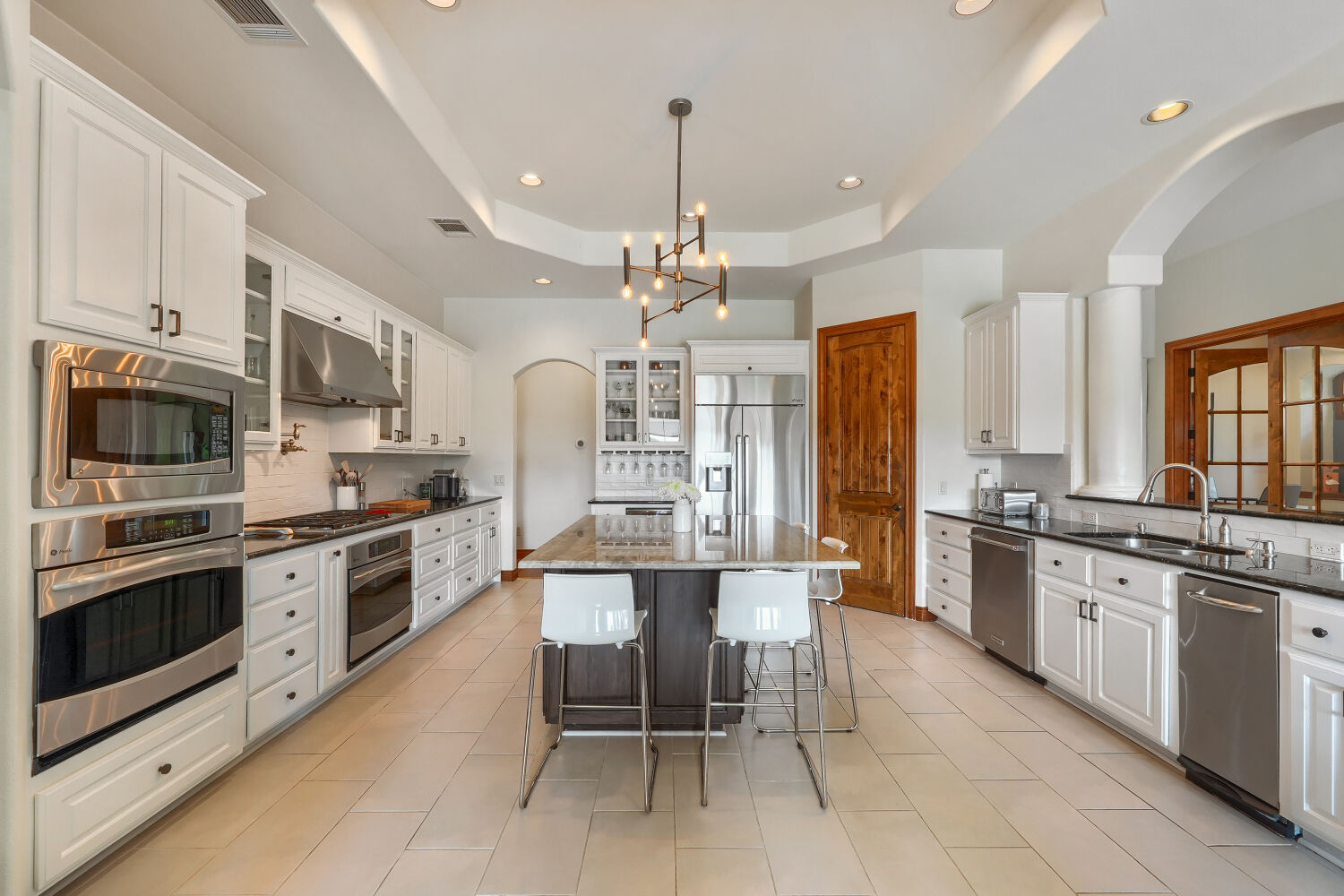 701 Hurst Creek Road Lakeway, TX 78734 - Photo 11 of 37 Gourmet kitchen with a central island, recessed lighting, stainless steel appliances, white cabinetry, and granite countertops