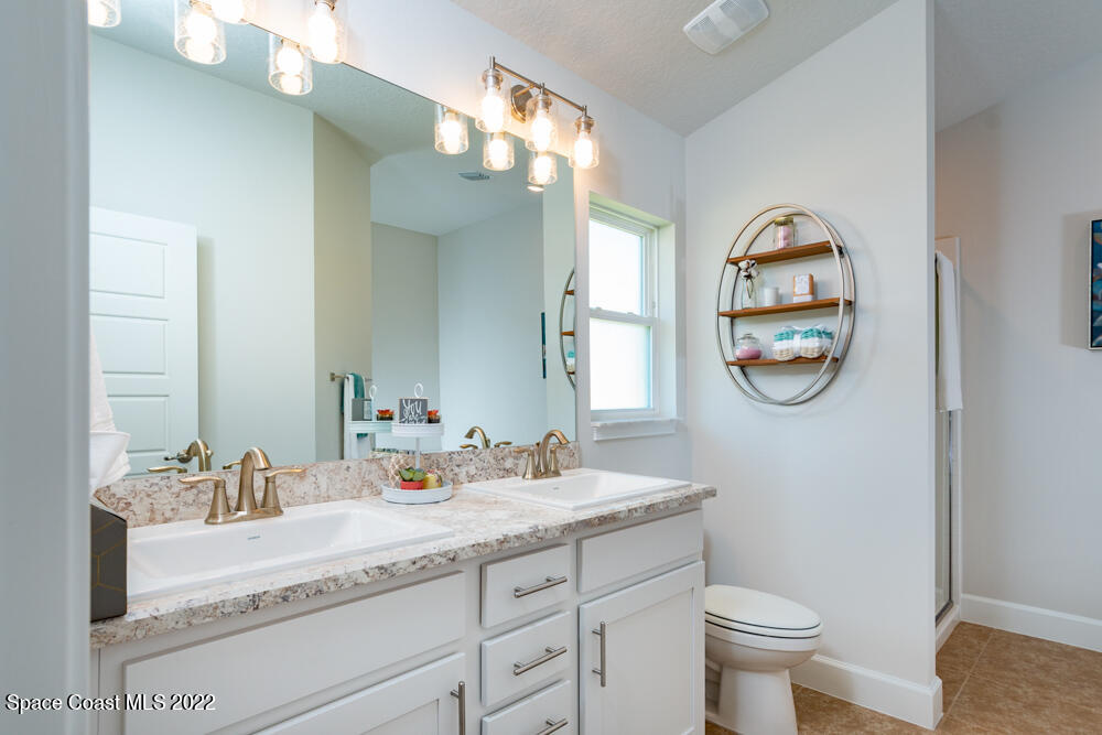 401 Scarlet Road Southwest Palm Bay, FL 32908 - Photo 15 of 24 a bathroom with a granite countertop sink and a mirror