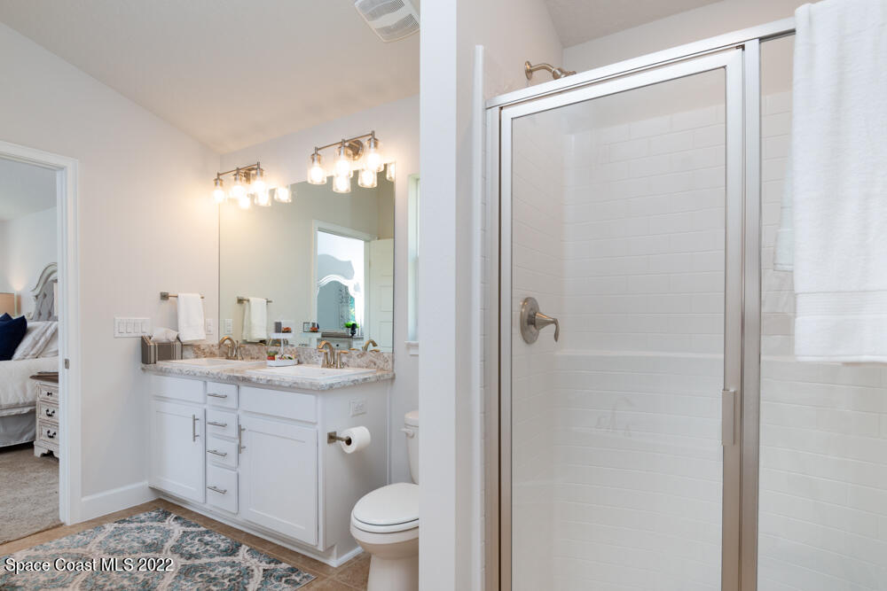 401 Scarlet Road Southwest Palm Bay, FL 32908 - Photo 16 of 24 a bathroom with a double vanity sink toilet and a mirror