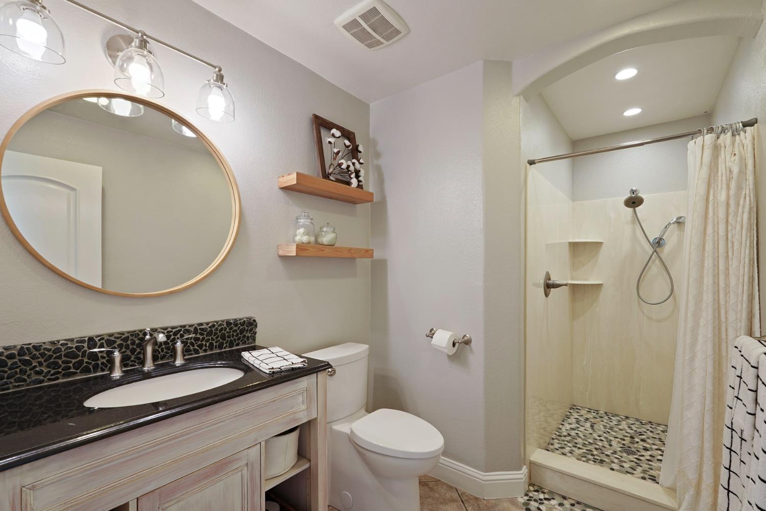 20820 East Acampo Road Clements, CA 95227 - Photo 21 of 28 a bathroom with a sink a toilet and a mirror