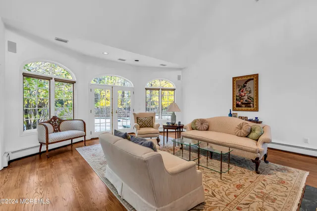 a bathroom with a tub a sink and a large mirror