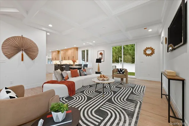 a living room with furniture kitchen view and a flat screen tv