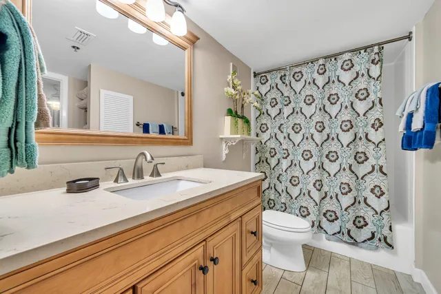 a bathroom with a granite countertop sink and a toilet