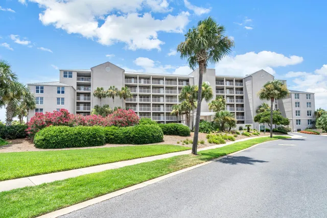 a front view of multi story residential apartment building with yard and green space