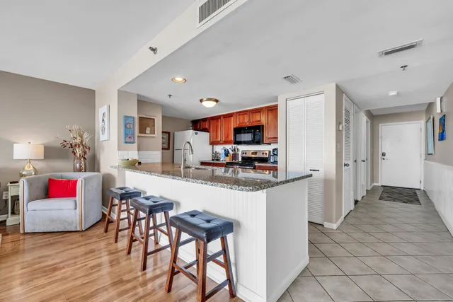 a kitchen with stainless steel appliances kitchen island granite countertop a refrigerator and a stove top oven