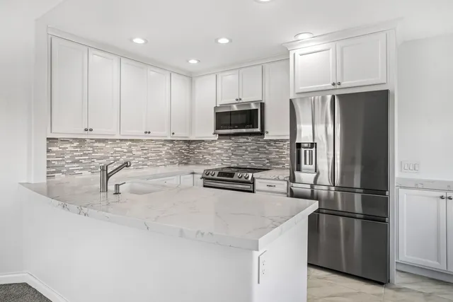a kitchen with granite countertop a refrigerator and a sink