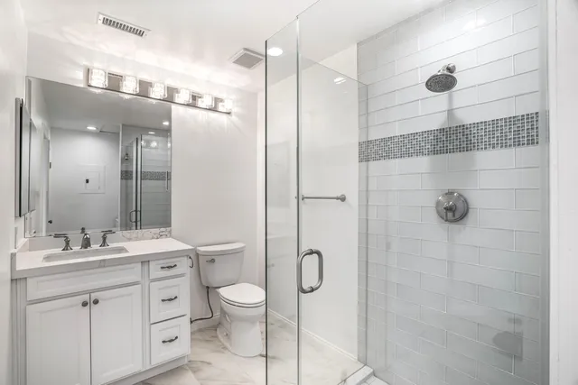 a bathroom with a double vanity sink toilet and shower