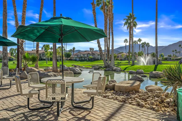 a view of a patio with chairs and table under an umbrella