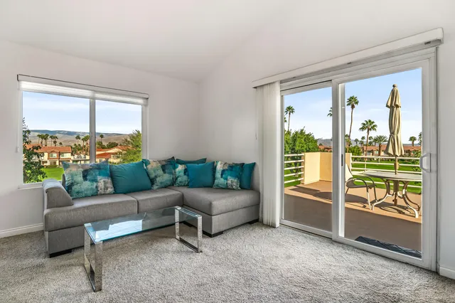 a living room with furniture and a floor to ceiling window