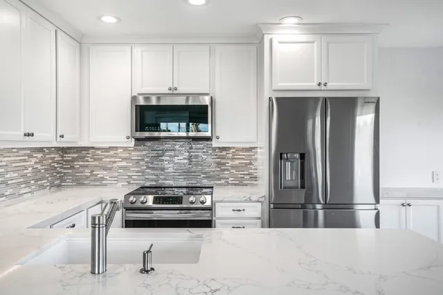 a kitchen with granite countertop a stove and a refrigerator