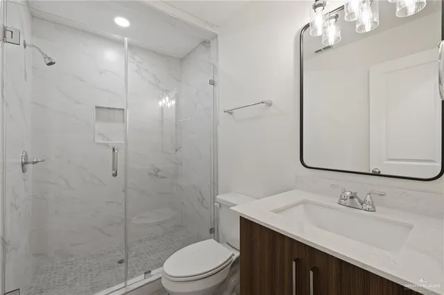 a bathroom with a sink a toilet and shower