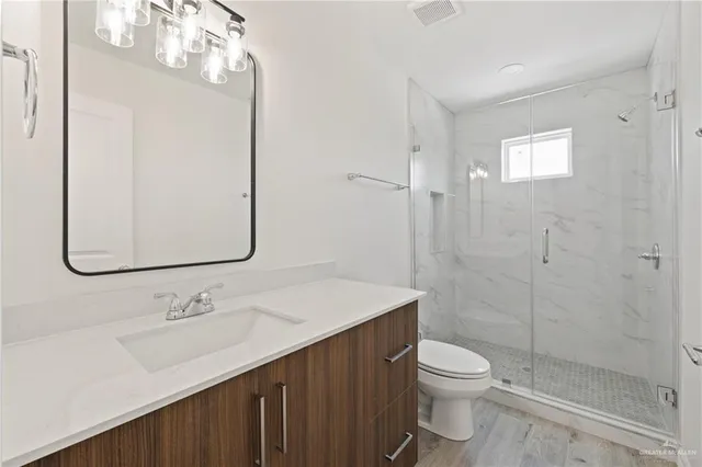 a bathroom with a sink a toilet and shower