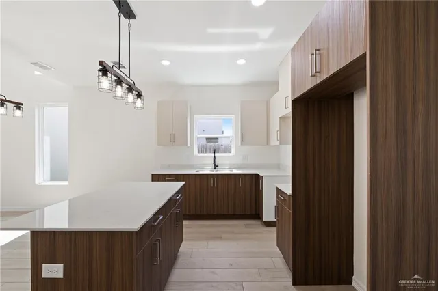 a kitchen with a sink a counter top space stainless steel appliances and a window