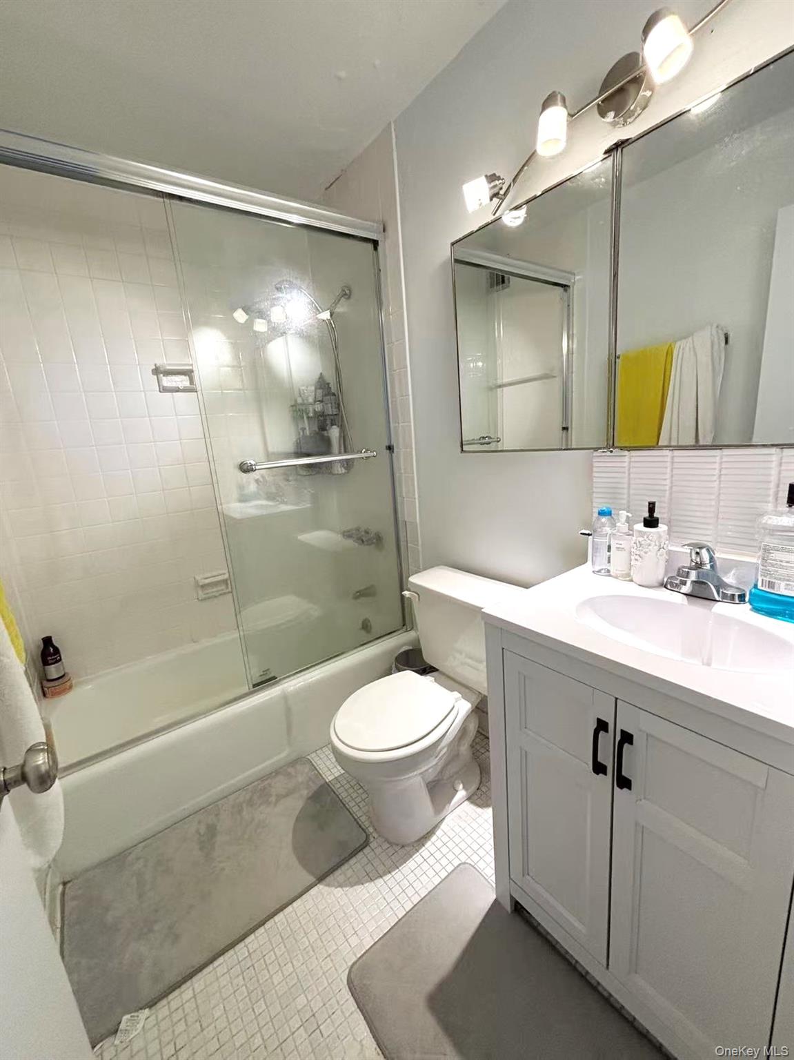 4140 Union Street, Unit 17A Queens, NY 11355 - Photo 9 of 10 Bathroom with combined bath / shower with glass door, vanity, backsplash, and light tile patterned flooring